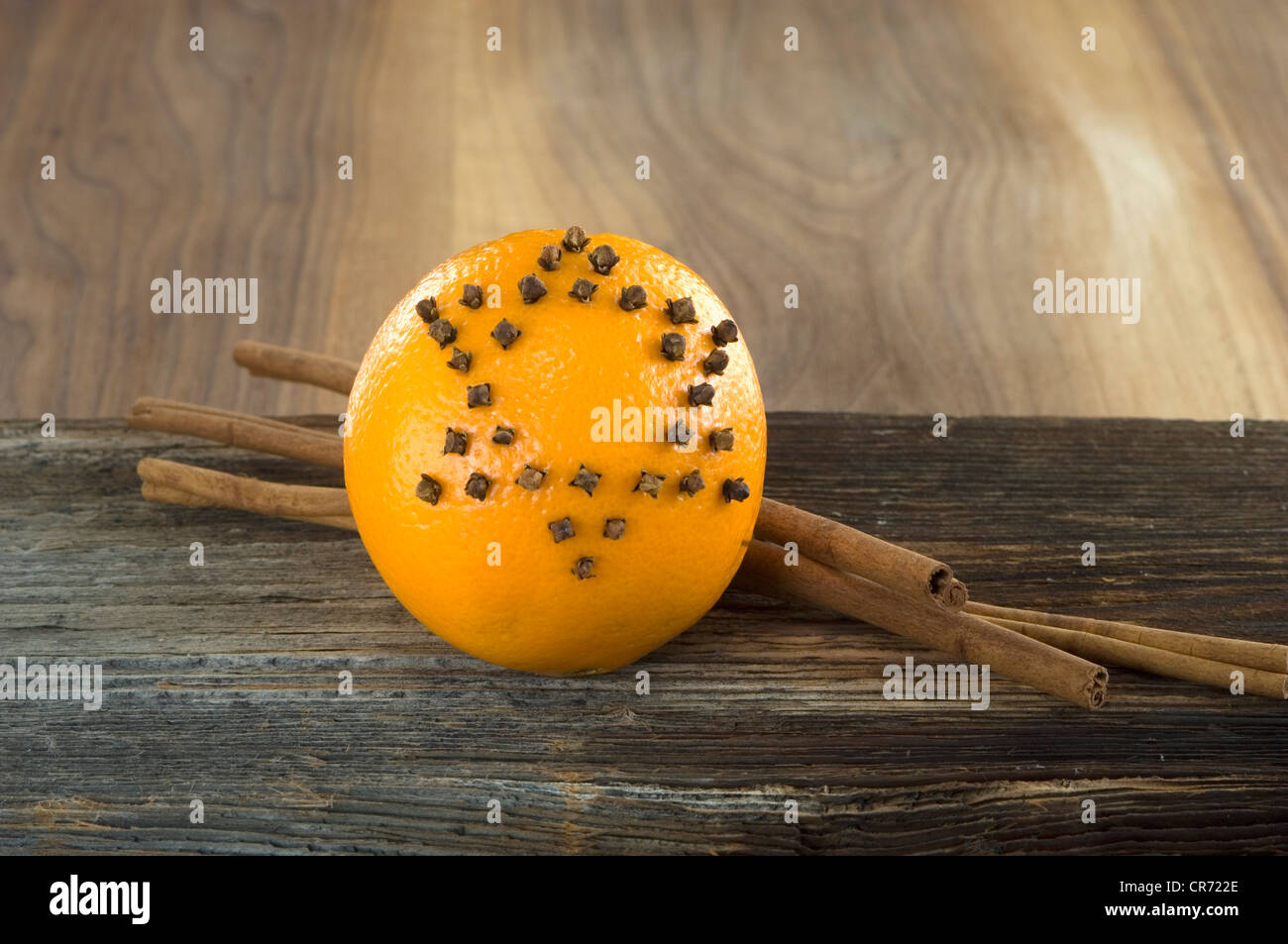 Orange studded with cloves and cinnamon stick on table, close up Stock Photo