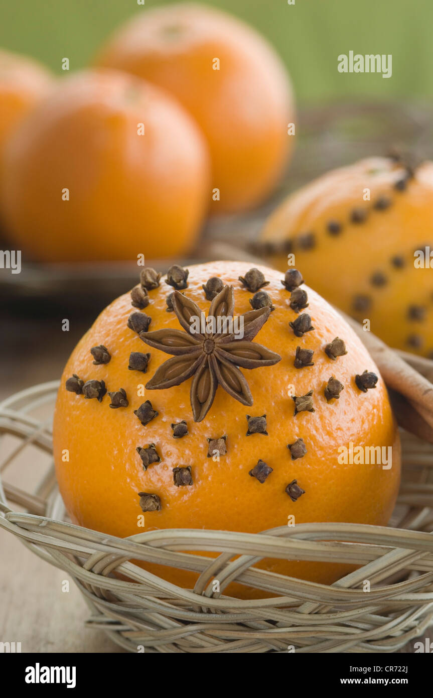 Orange studded with cloves and star anise in basket Stock Photo