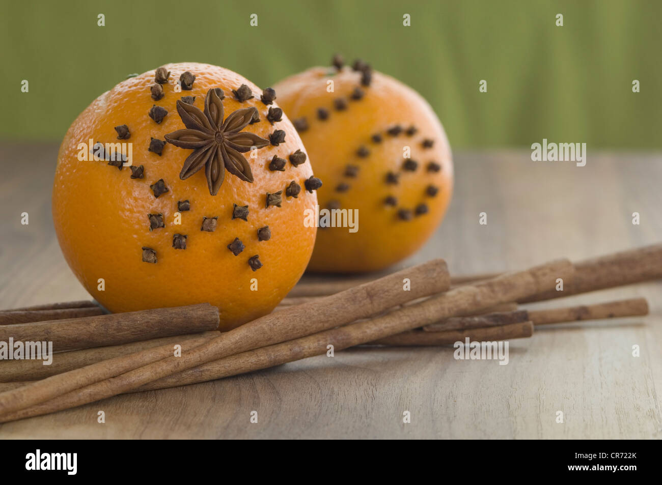 Orange studded with cloves and star anise, cinnamon stick on table Stock Photo