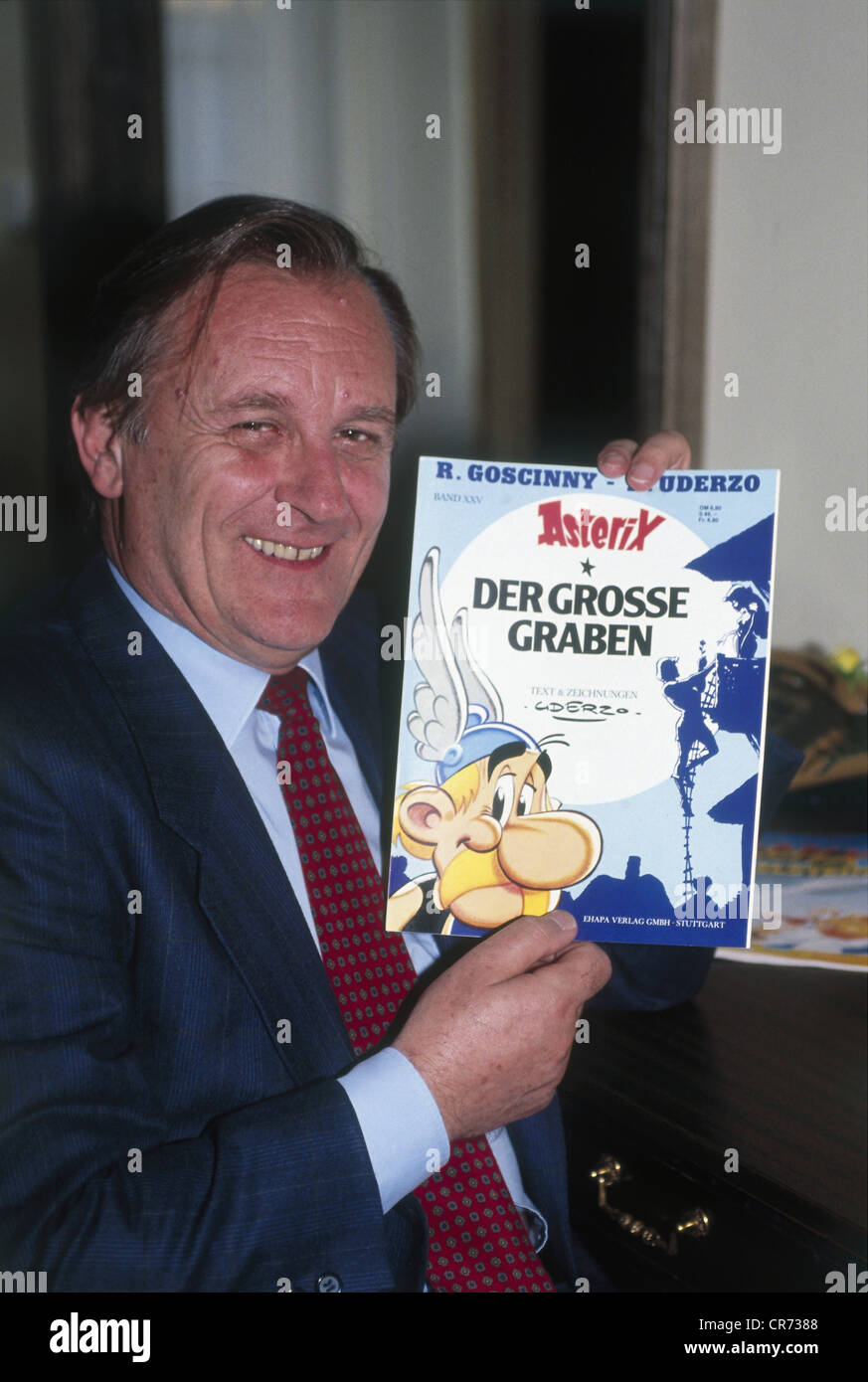 Uderzo, Albert, * 25.4.1927, French comic book artist, scriptwriter, half length, during the premiere of the movie 'Asterix - Operation Hinkelstein' in Munich, Germany, October 1989, showing his book 'Der grosse Graben' (Le Grand Fosse), Stock Photo