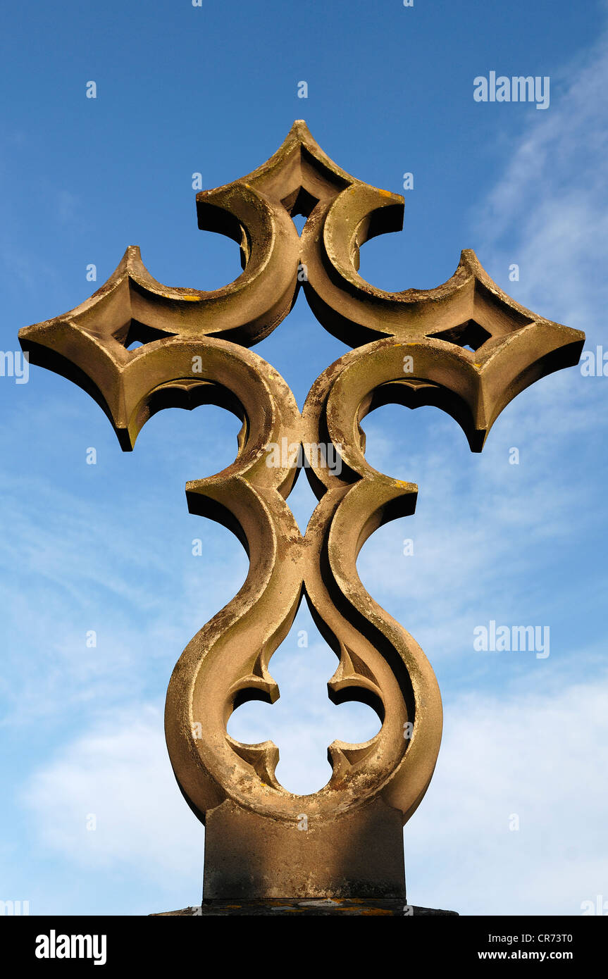 Unusually designed stone cross on a grave, 19th Century, against a blue sky in the cemetery of Guebwiller, Route de Colmar Stock Photo