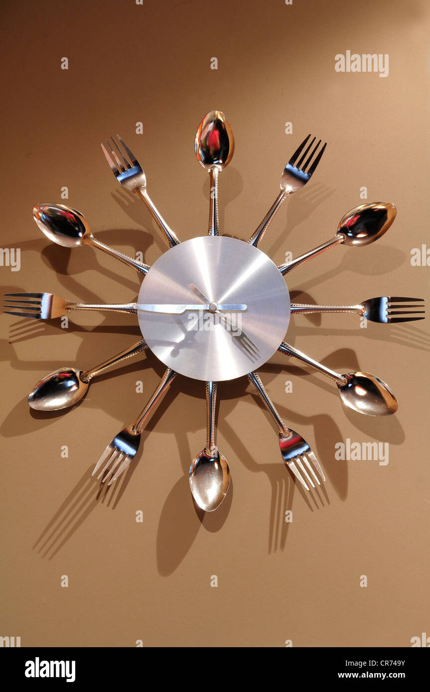 Wall clock made of cutlery on a wall Stock Photo
