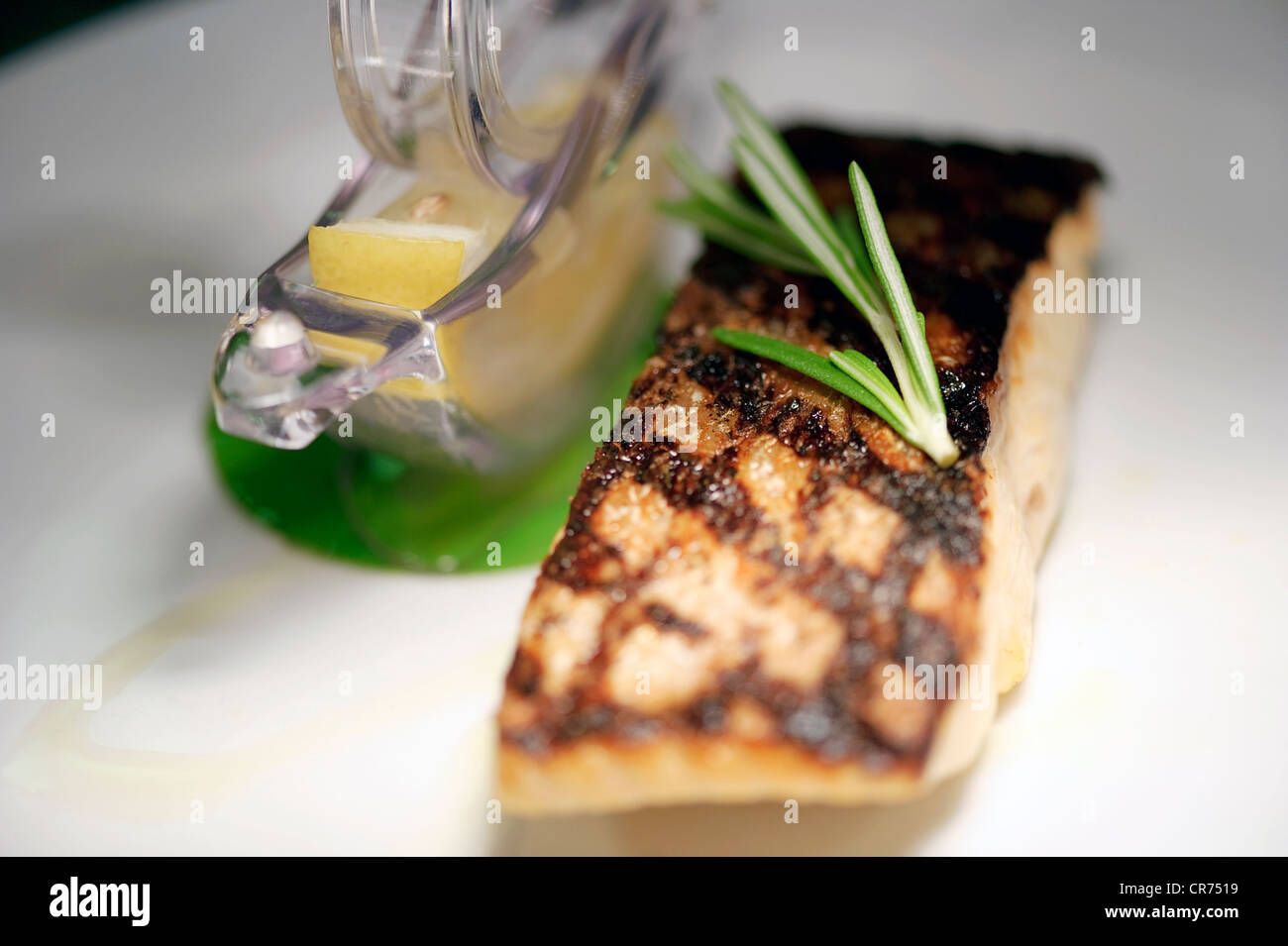 grilled salmon with rosemary and lemon on white restaurant plate Stock Photo