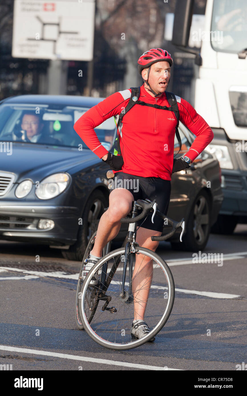 Tired cyclist waiting to turn into Victoria Embankment, London Stock Photo
