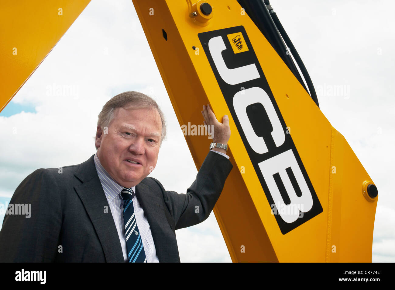 JCB Chairman Sir Anthony Bamford leaning on contruction machine Stock Photo