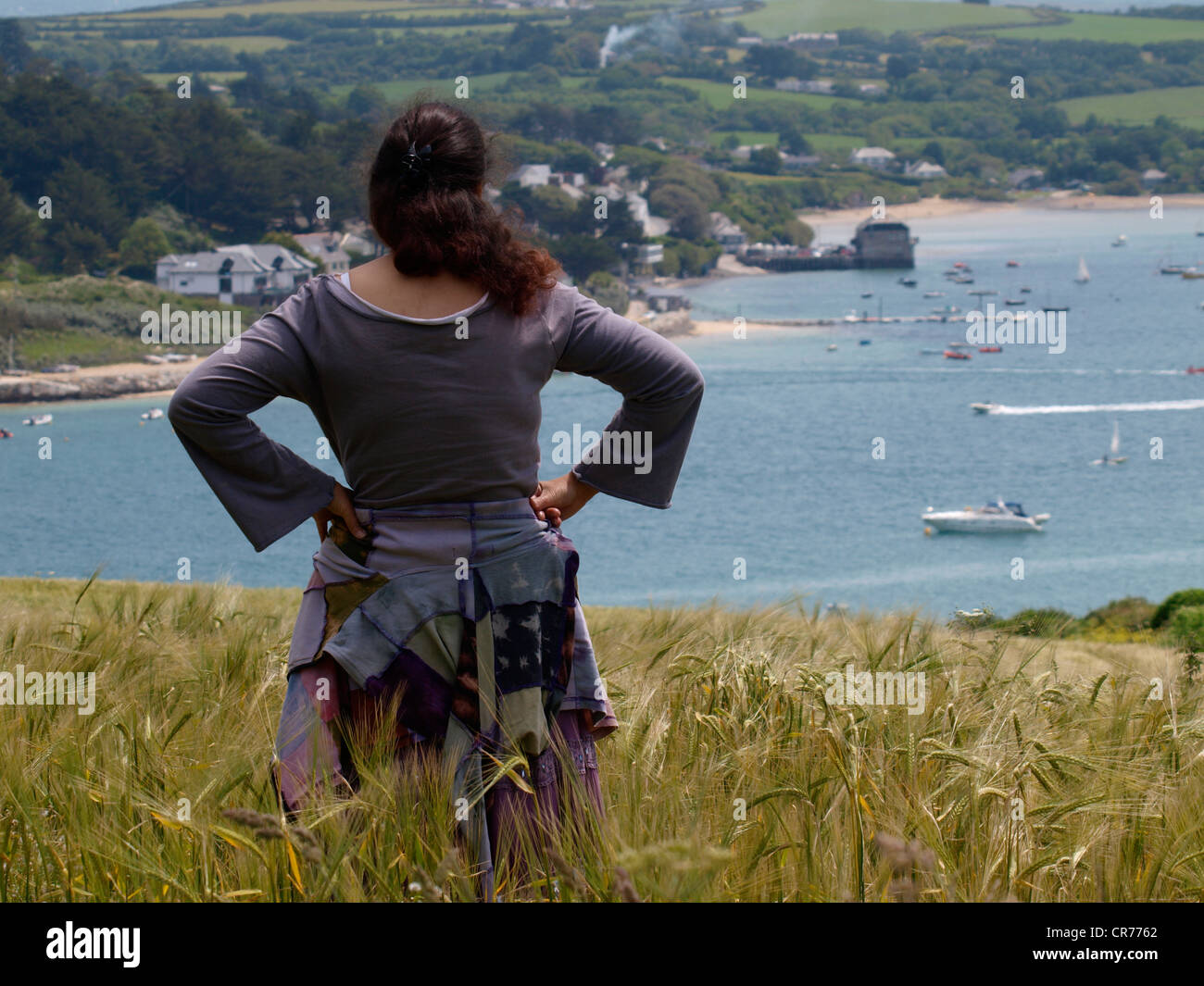 Woman standing in a corn field looking at the view, Padstow, Cornwall, UK Stock Photo