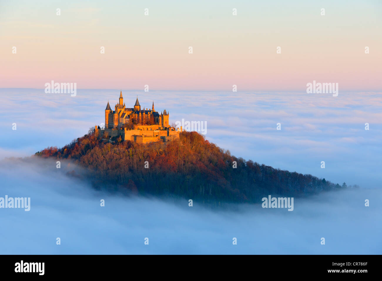 Burg Hohenzollern castle, in morning light, mist, with autumn forest, Schwaebische Alb, Swabian Alb, Baden-Wuerttemberg Stock Photo