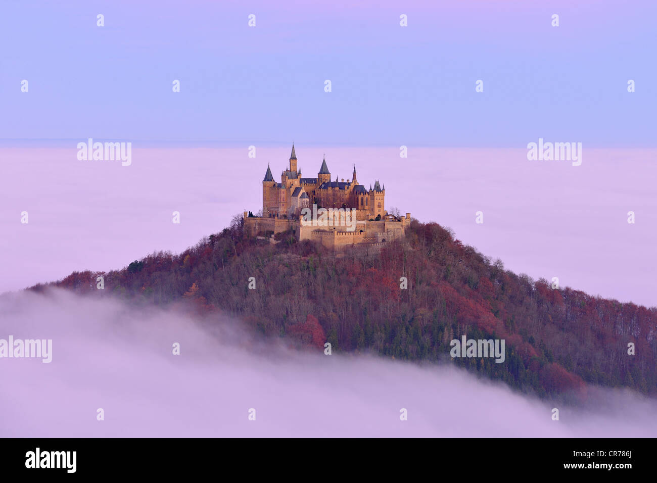 Burg Hohenzollern castle, in morning light, mist, with autumn forest, Schwaebische Alb, Swabian Alb, Baden-Wuerttemberg Stock Photo