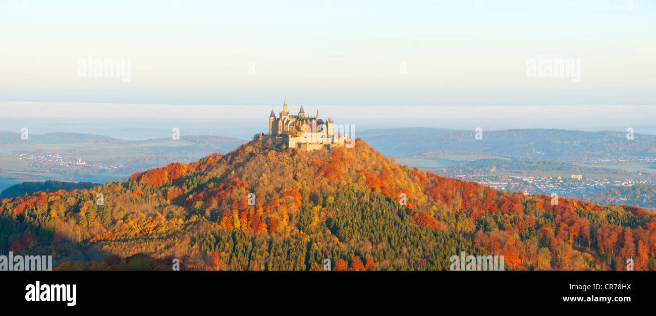 Burg Hohenzollern Castle in the early morning light and fog, with autumnal forest, Swabian Alb, Baden-Wuerttemberg Stock Photo