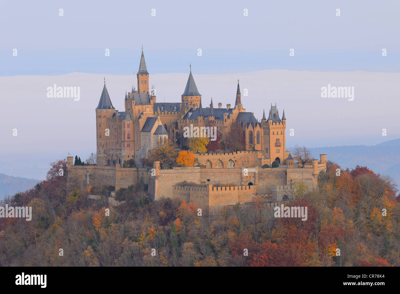 Burg Hohenzollern Castle in the early morning light with autumnal forest, early morning fog, Swabian Alb, Baden-Wuerttemberg Stock Photo