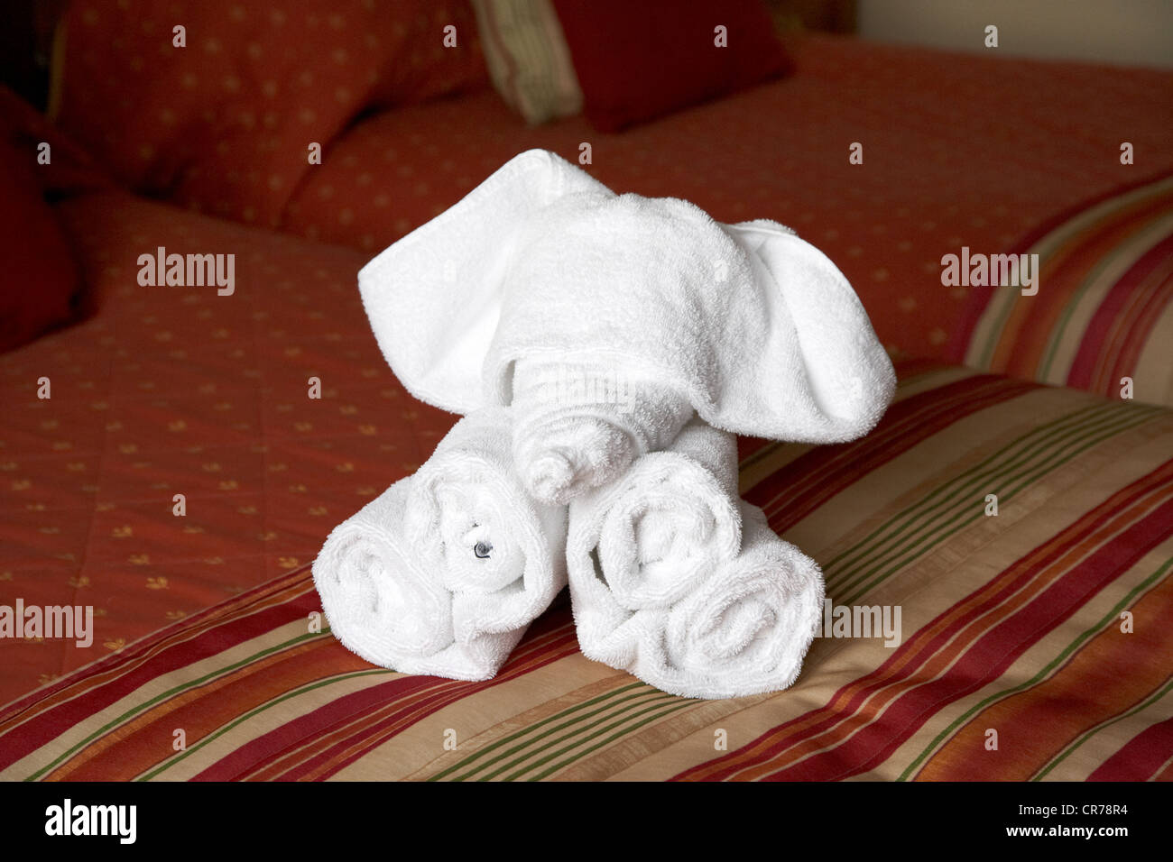 hotel towels folded into the shape of an elephant on a hotel bed in the