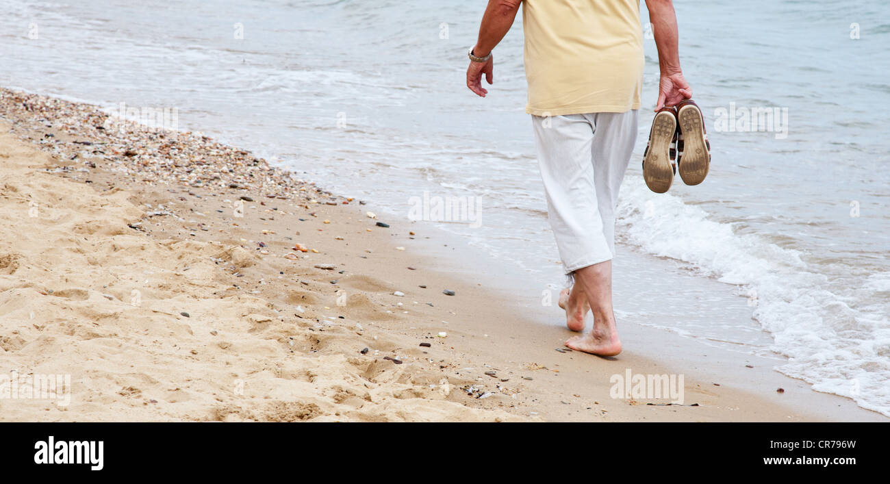 Retired person doing a beach stroll Stock Photo