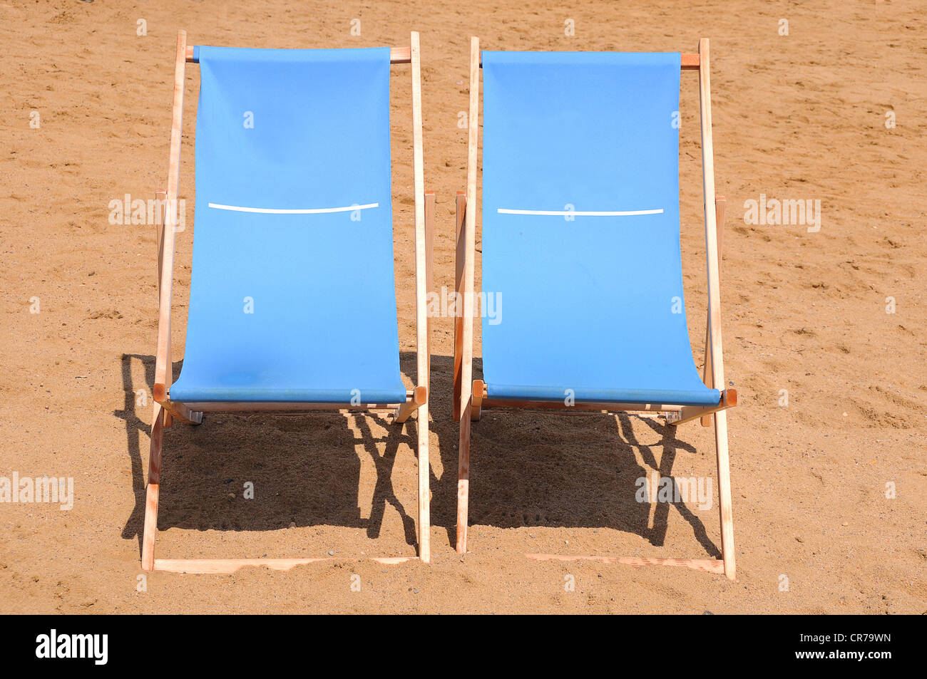 Two blue wooden deckchairs on the beach Stock Photo - Alamy