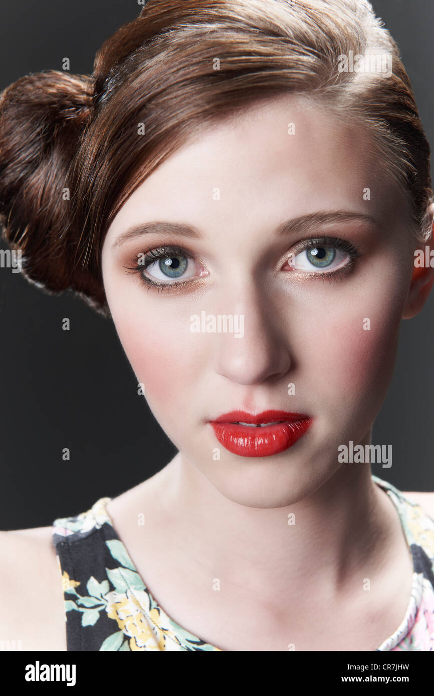 Vintage style portrait of model with red hair tied in a bun Stock Photo
