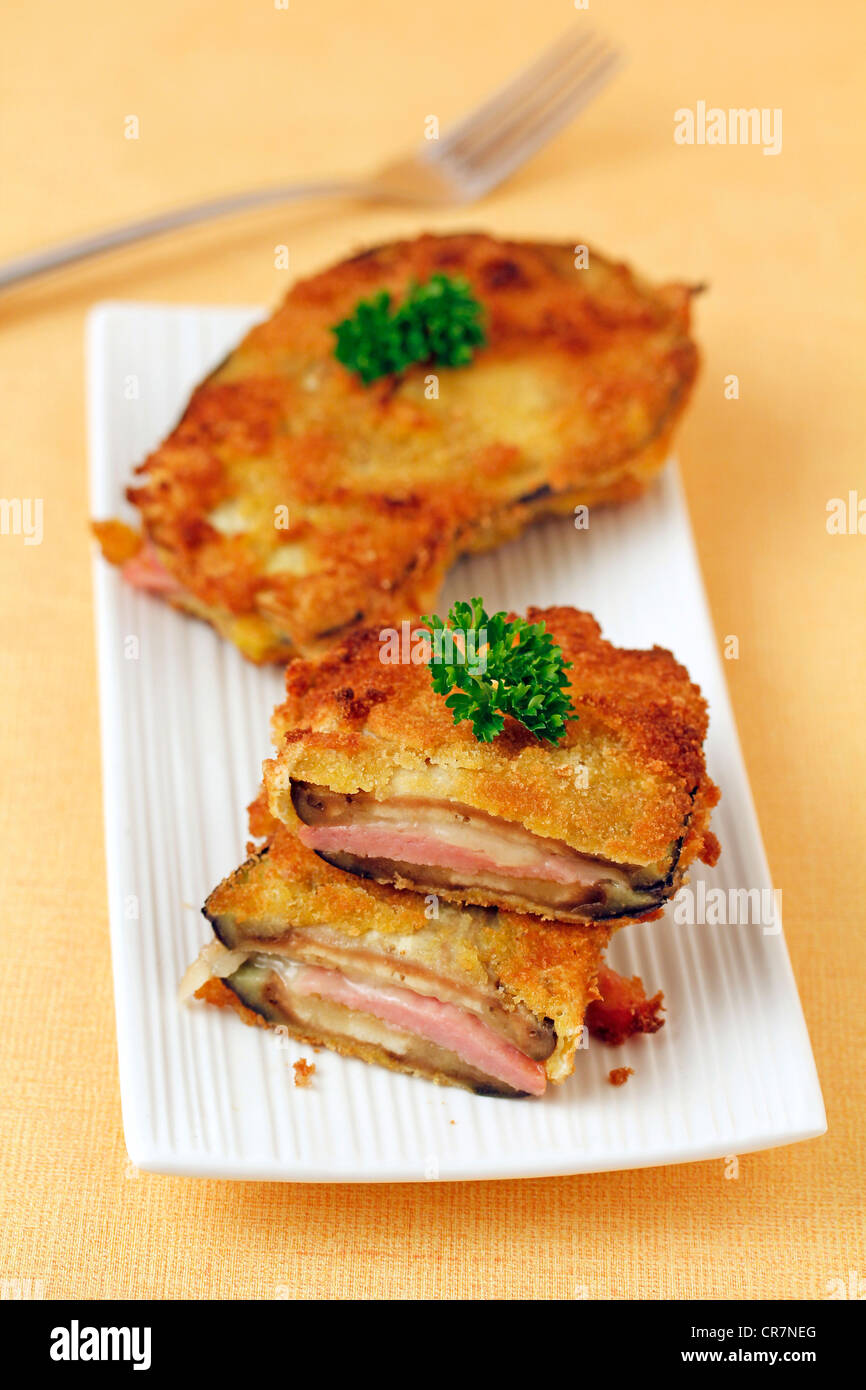 Breaded aubergines with ham and cheese. Recipe available Stock Photo