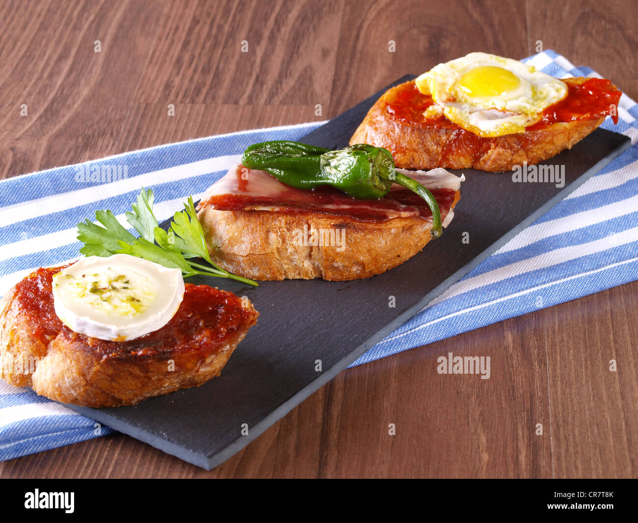 Set of three different montaditos. Montadito is an appetizer or snack (Spanish Tapa) made with a slice of bread with some other Stock Photo