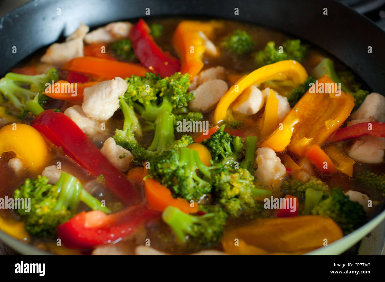 Colorful Chinese vegetable and chicken saute in wok Stock Photo