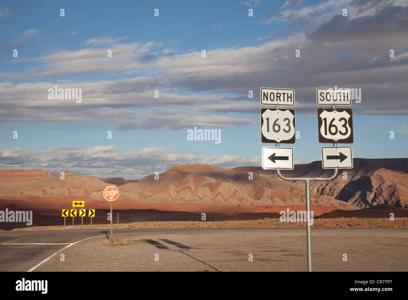 Road junction near Goosenecks State Park and Mexican Hat, southeast Utah, with unusual chevron rock patterns in the background. Stock Photo