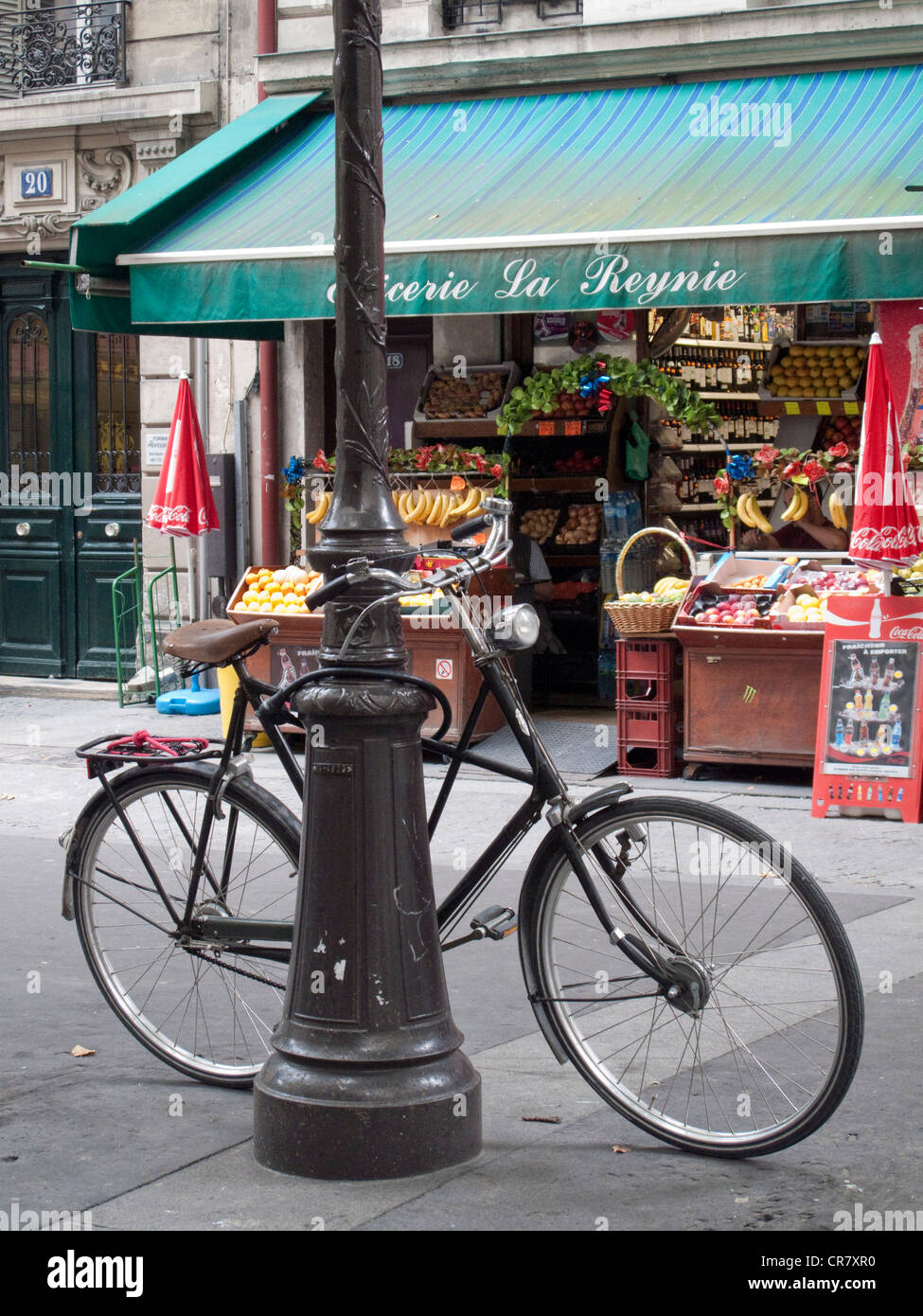 France, Paris, hanging bicycle at a lamppost in front of a neighborhood grocery store Stock Photo