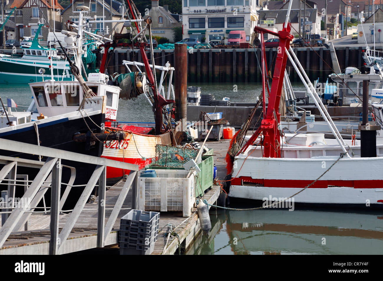Gangway, landing stage, fish boxes and crates, and fishing vessels in the harbour of Grandcamp-Maisy, Normandy, France Stock Photo