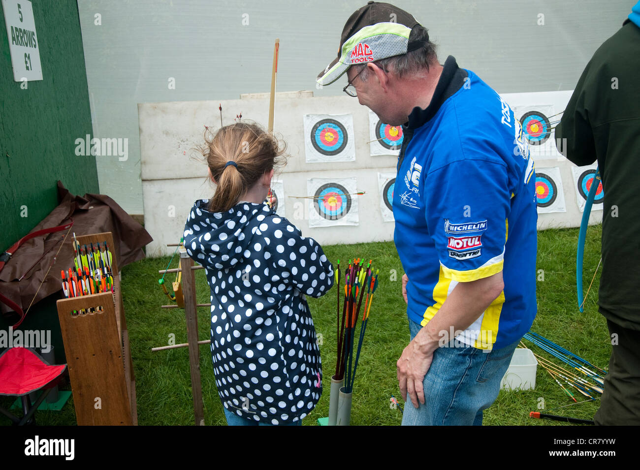 Cornwall, England, UK - Man teaching girl  how to use bow and arrow. Stock Photo