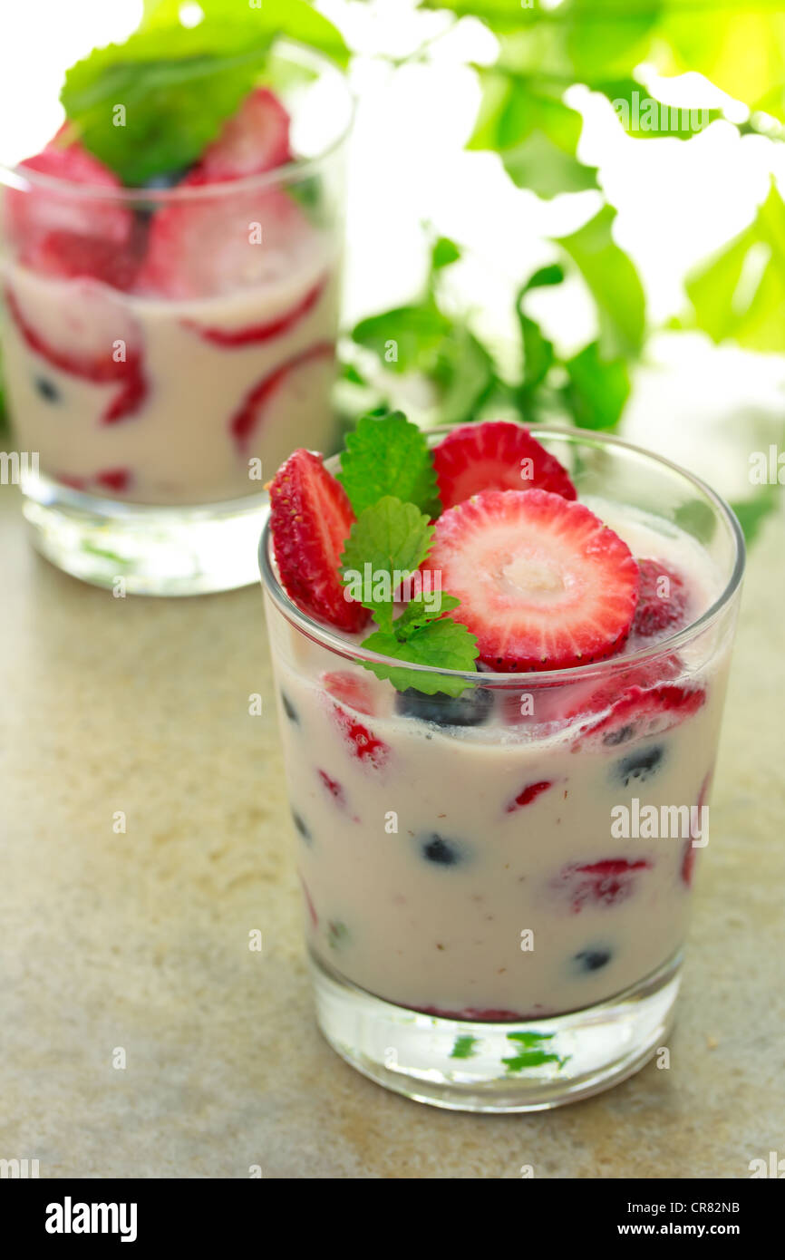 Vanilla yogurt with strawberries, blueberries and lemon balm Stock Photo