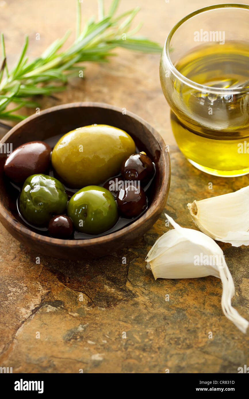 Olive oil and mixed olives with garlic cloves Stock Photo