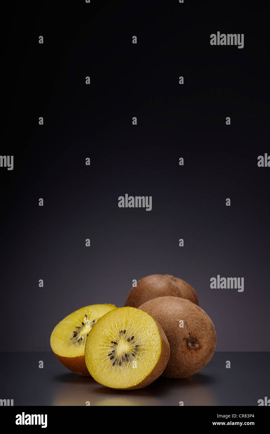 Kiwifruit (Actinidia deliciosa) on a dark glass surface Stock Photo