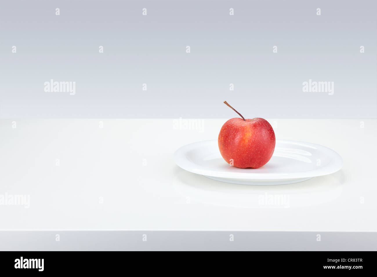 Red apple (Malus domestica), Boskoop variety, on a white plate Stock Photo