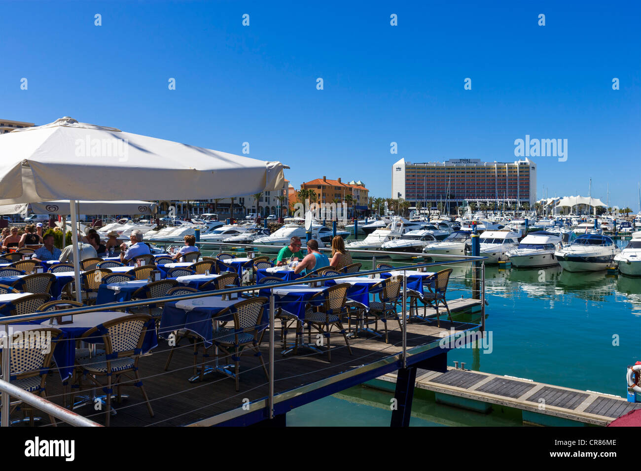 Restaurant terrace overlooking the marina in Vilamoura with the Hotel Tivoli in the background, Algarve, Portugal Stock Photo