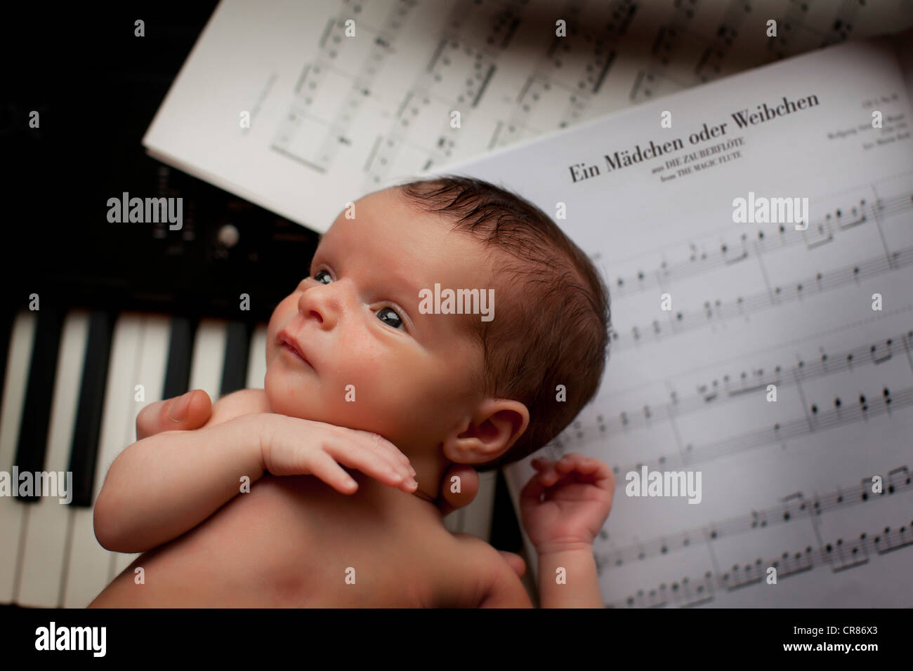 Newborn baby, two weeks, piano, sheet music Stock Photo