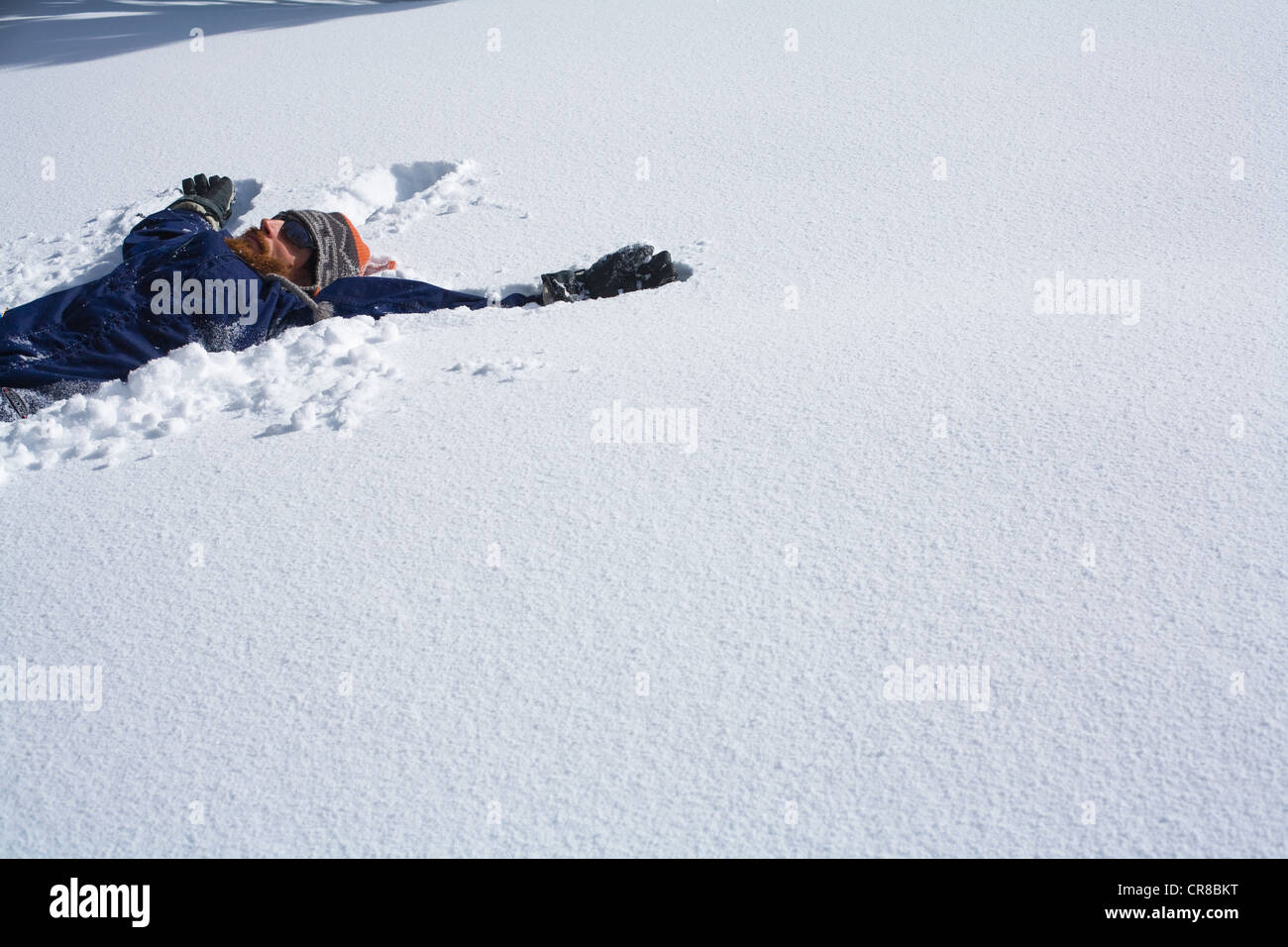 Snowboarder making a snow angel Stock Photo