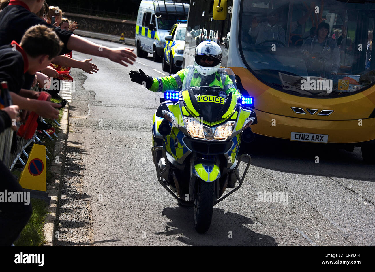 Police motorbike rider escorting coach with the Olympic torch Stock Photo