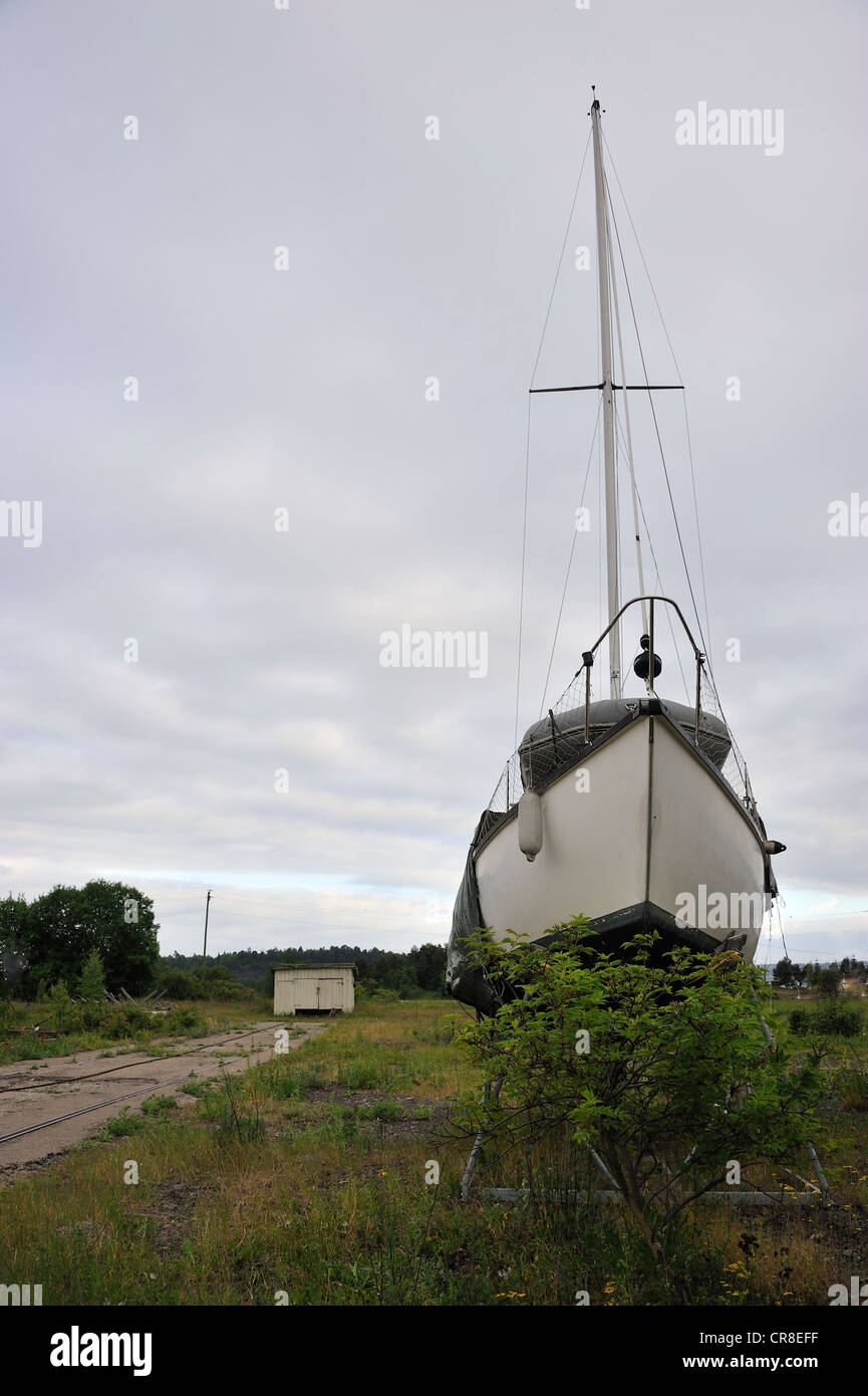 Sailboat on land behind a bush. Stock Photo