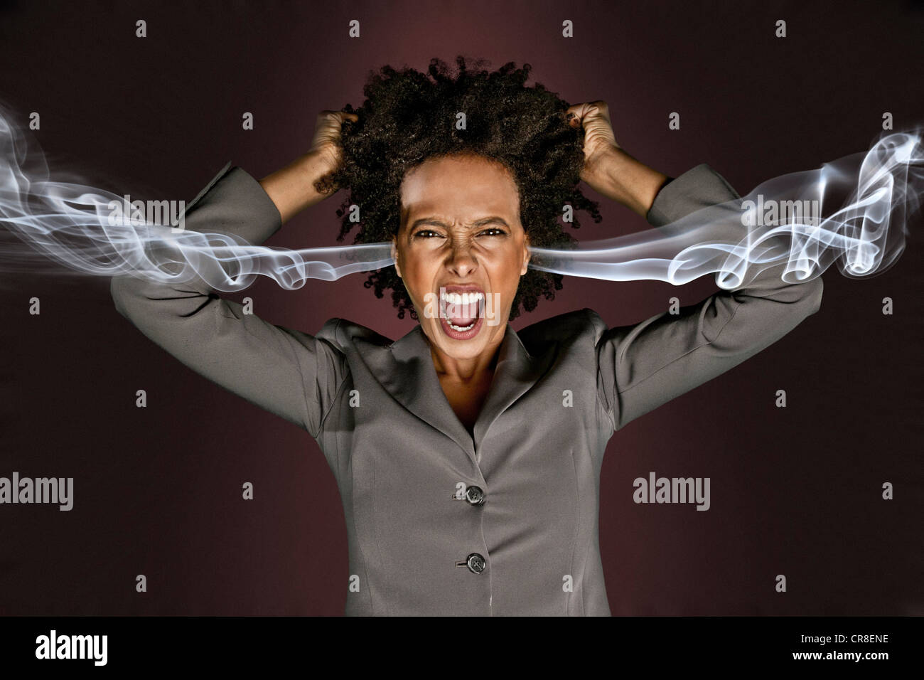 Frustrated woman with smoke coming from ears Stock Photo