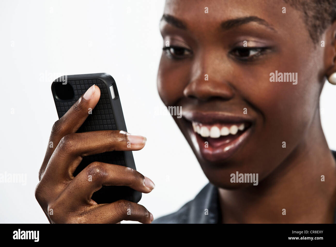 Young woman holding cellphone against white background Stock Photo