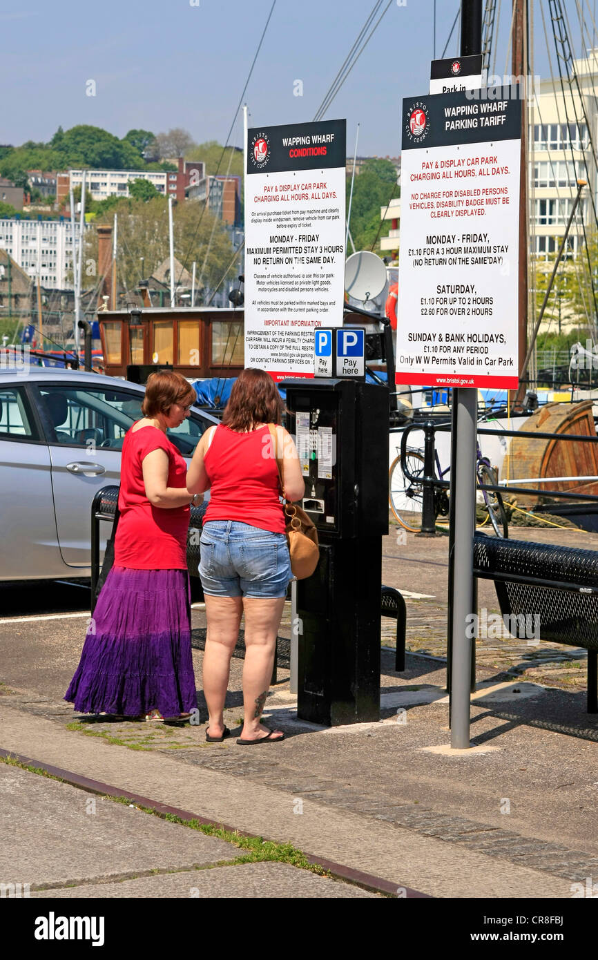 Two women feeding the car Park machine as Pay and Display is the norm in  Bristol Stock Photo - Alamy