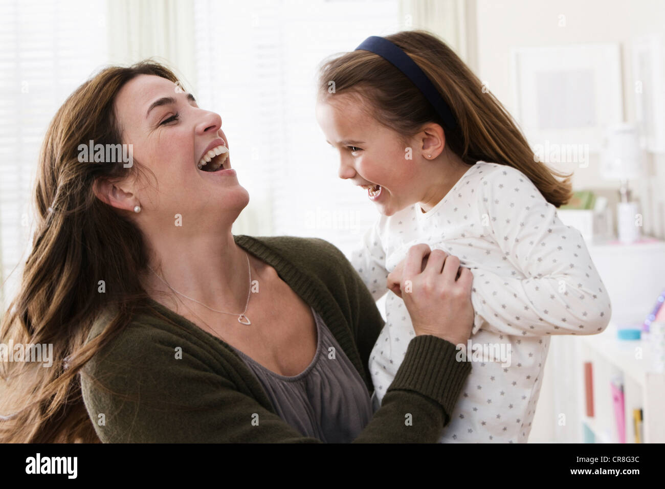 Mid adult woman holding daughter, smiling Stock Photo