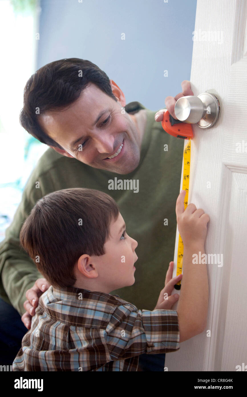 Father and son measuring door at home Stock Photo