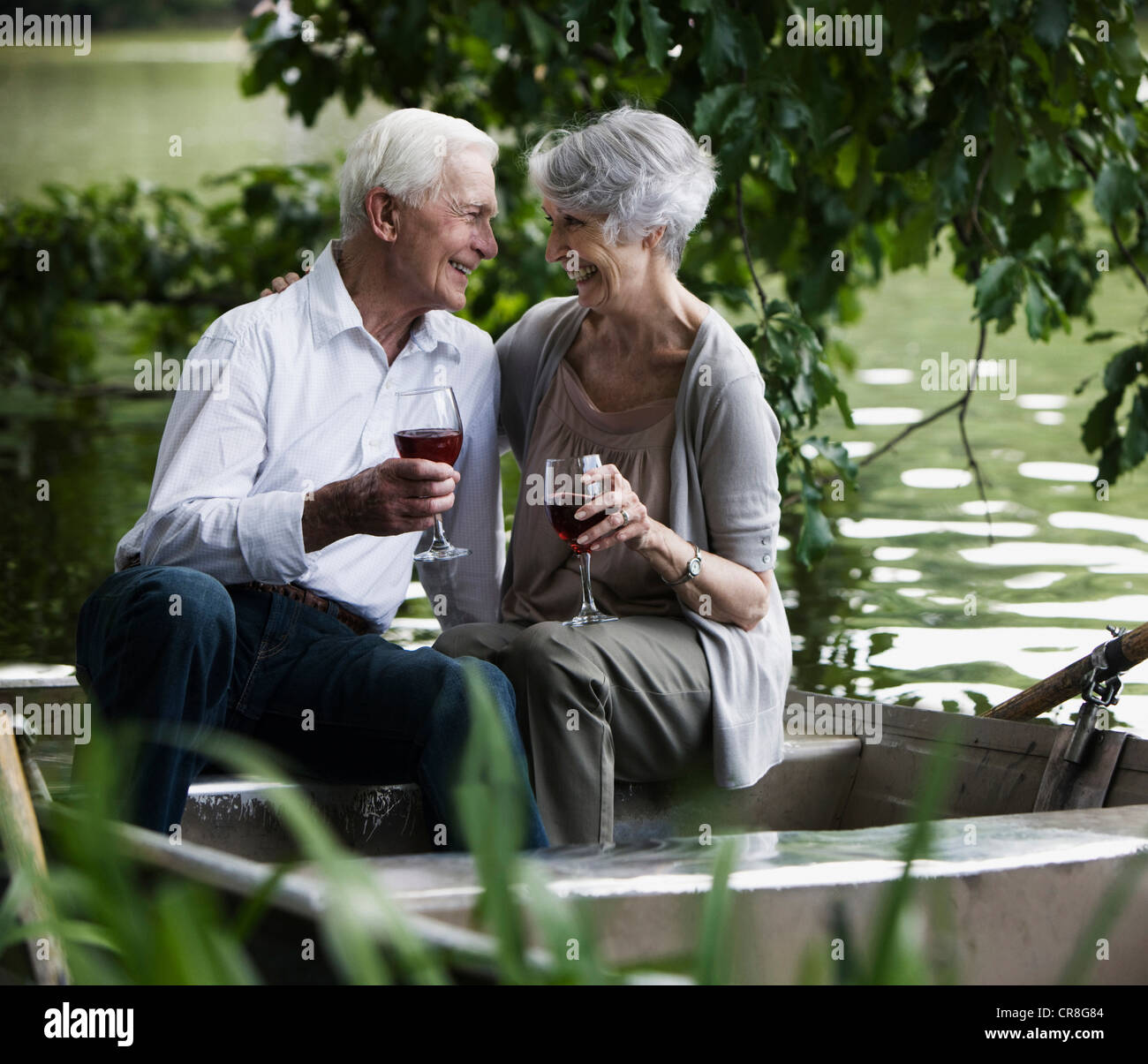 Senior couple drinking wine on rowing boat Stock Photo