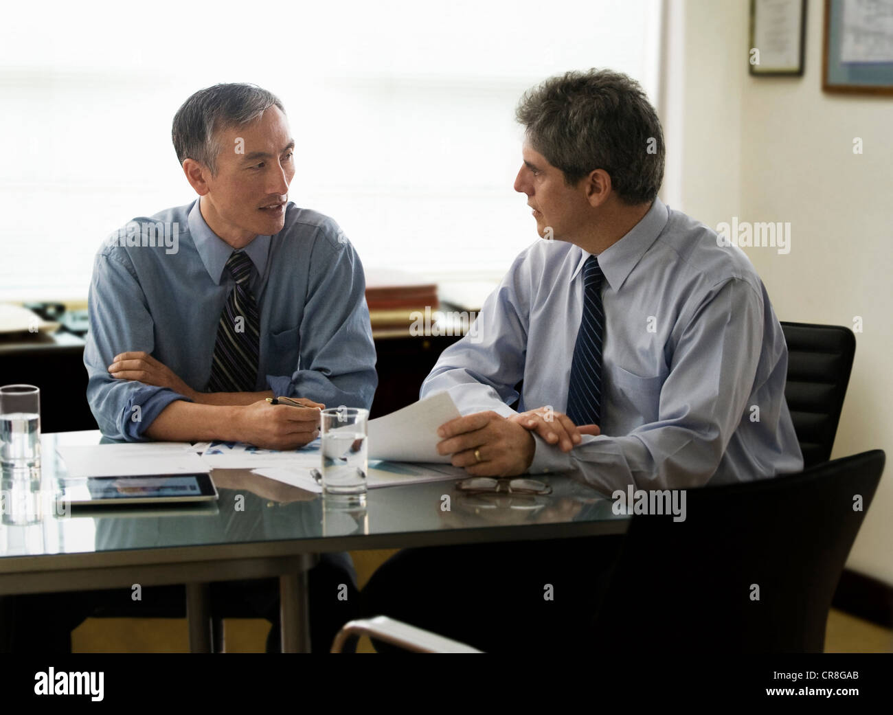 Businessmen discussing report in office Stock Photo