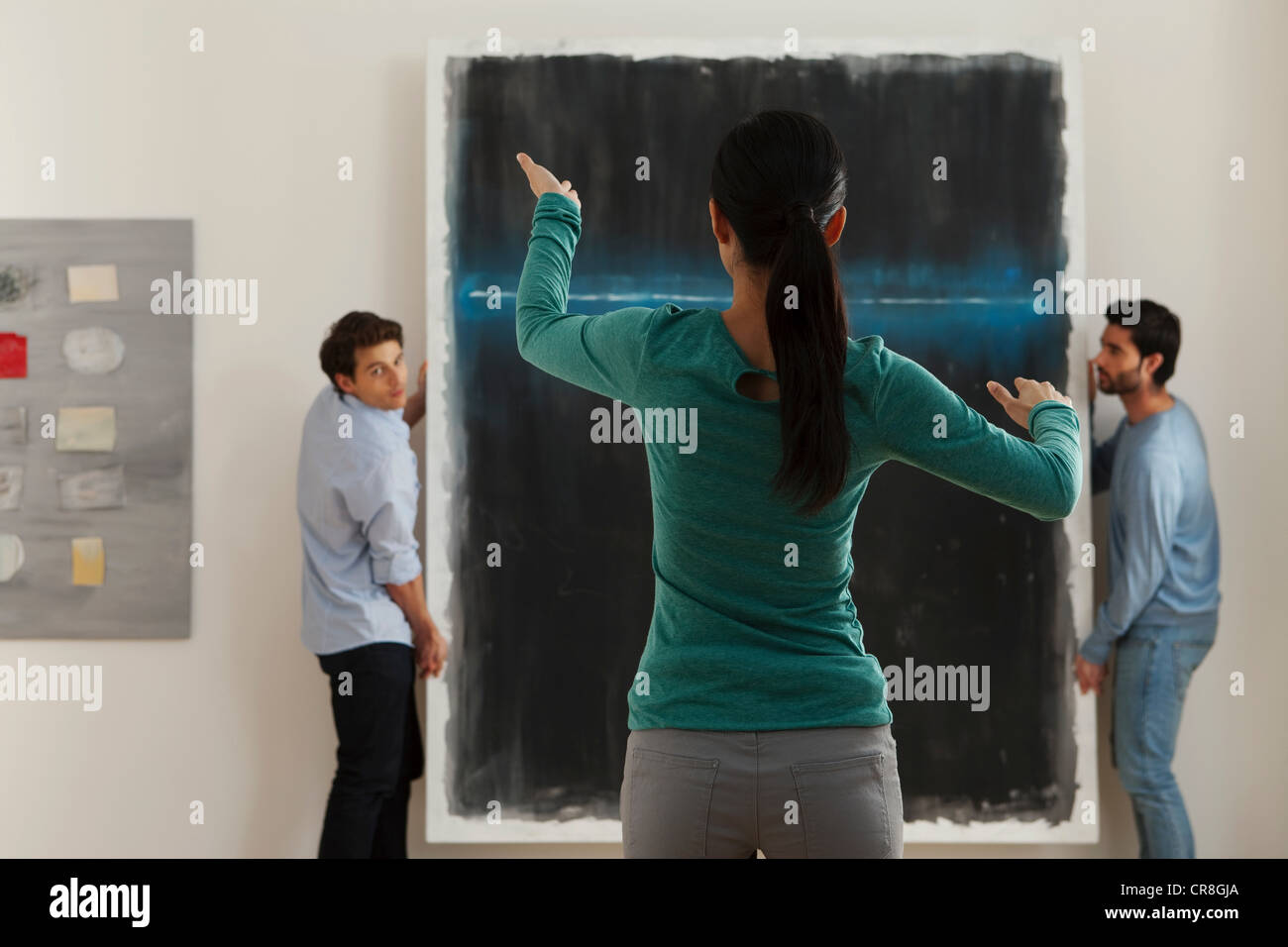 Art dealer arranging hanging of oil painting in gallery Stock Photo Alamy