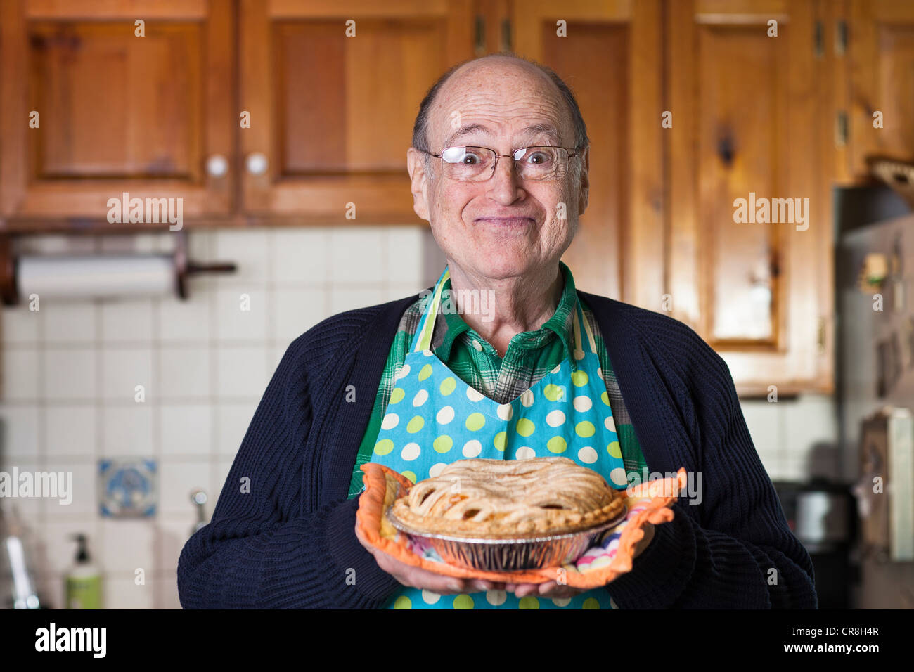 Senior man holding freshly baked pie, portrait Stock Photo