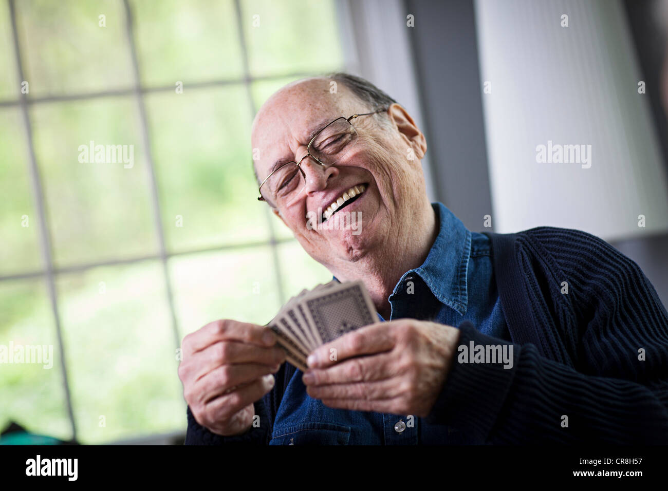 Senior man playing card game at home Stock Photo - Alamy