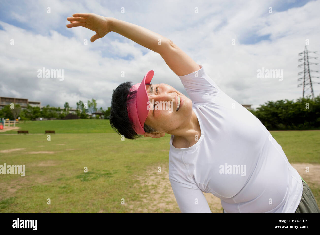 Senior woman stretching in a park Stock Photo