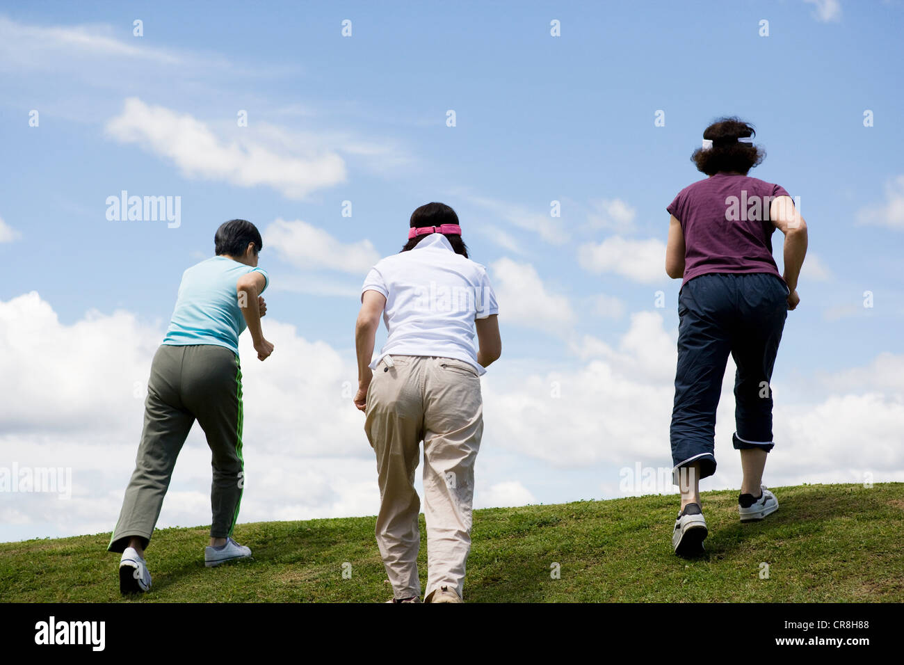 Three senior women walking up a hill Stock Photo