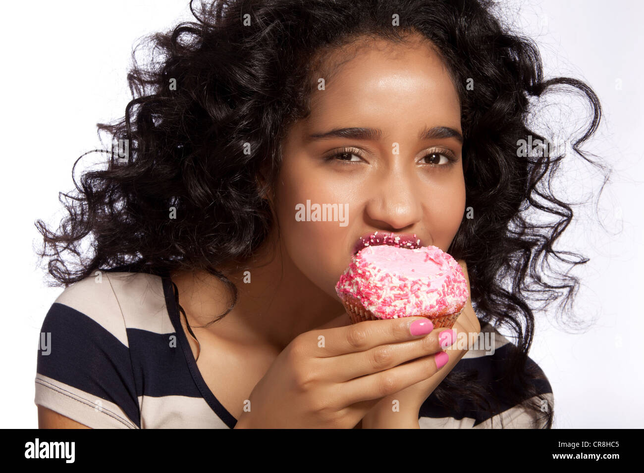 Young woman eating cupcake, studio shot Stock Photo Alamy