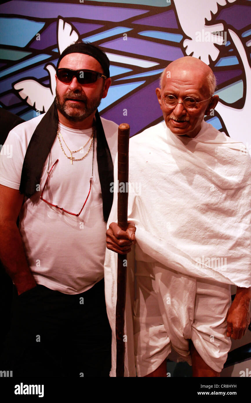 Man posing next to the wax statue of Mahatma Gandhi at the madame tussauds Stock Photo