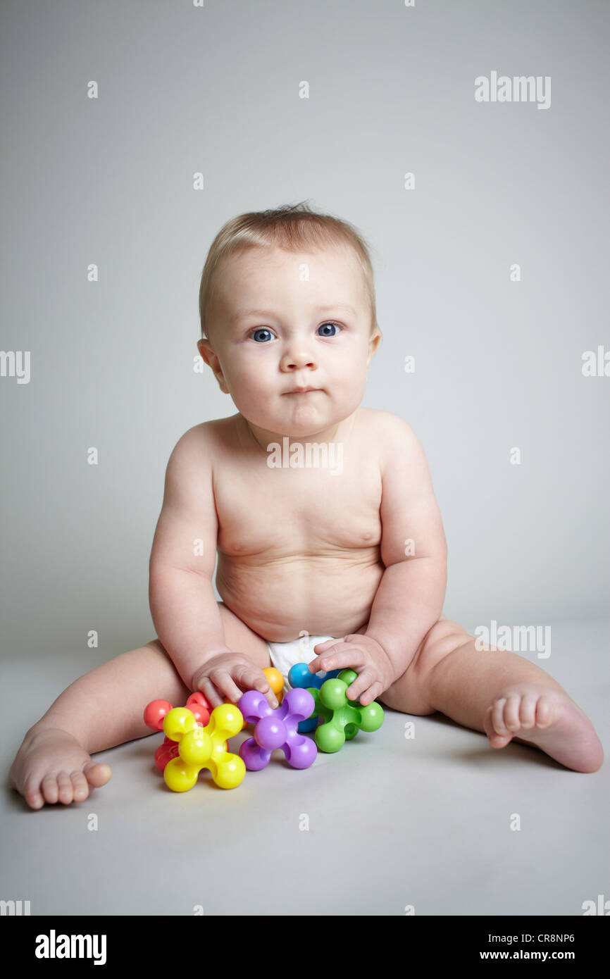 Baby boy playing with jacks Stock Photo