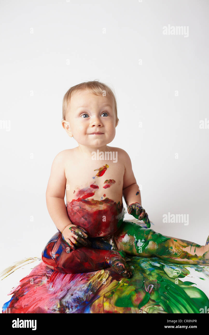 Baby covered in messy paint Stock Photo Alamy